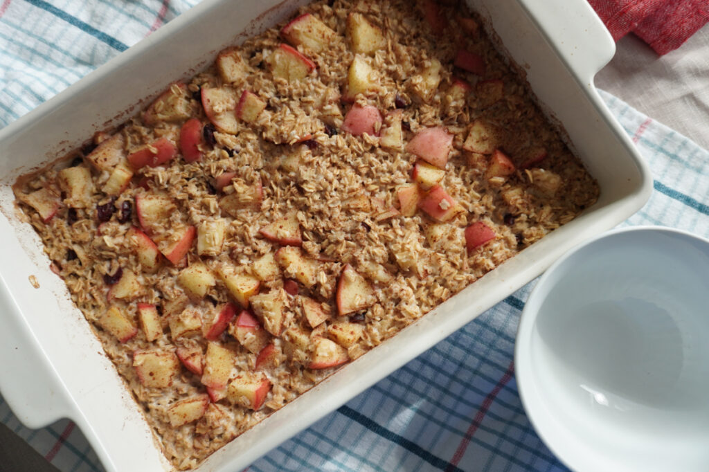 Baked apple cinnamon oatmeal with hearty apple chunks in a baking dish