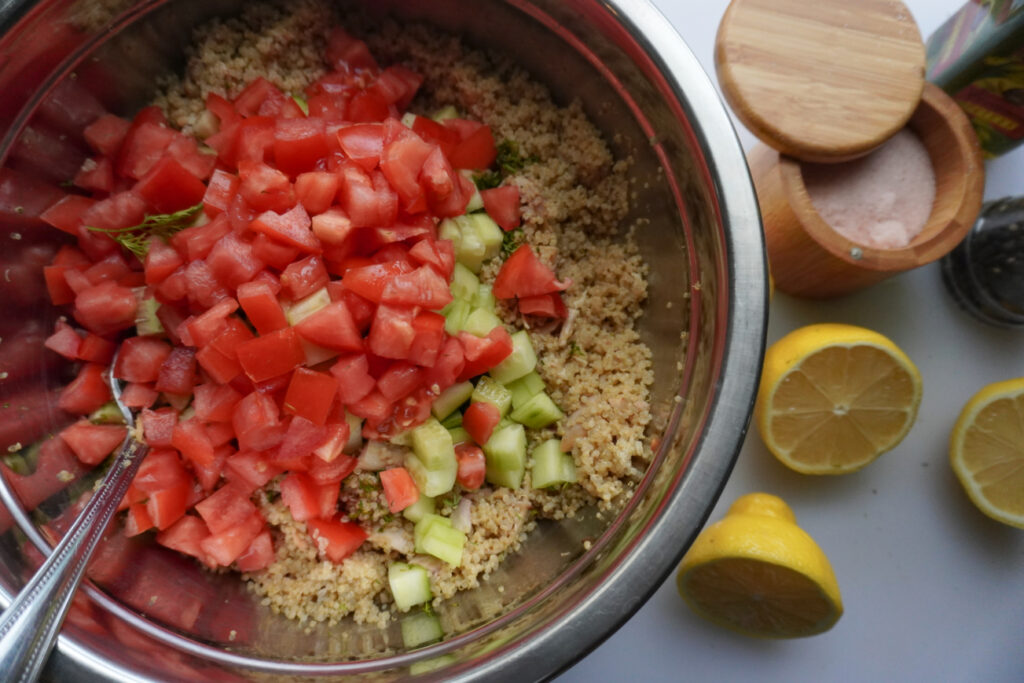 a mixing bowl with ingredients for Mediterranean quinoa salad with chicken
