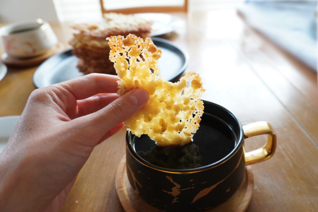person dipping a buttery oatmeal cookie into a cup of coffee