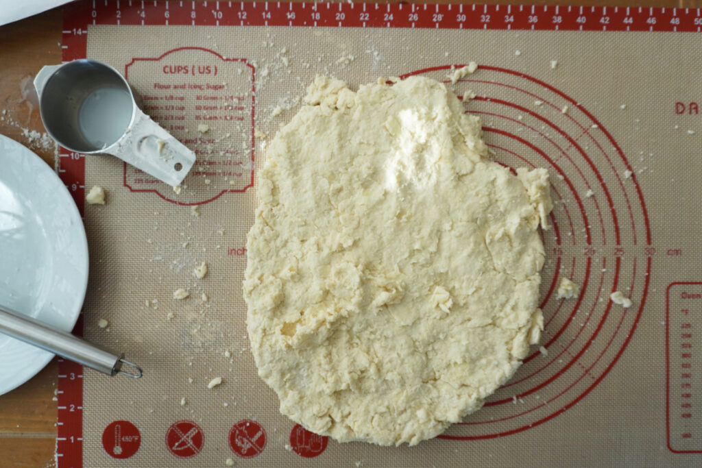 a round of biscuit dough pressed out on a silicone pastry dough mat