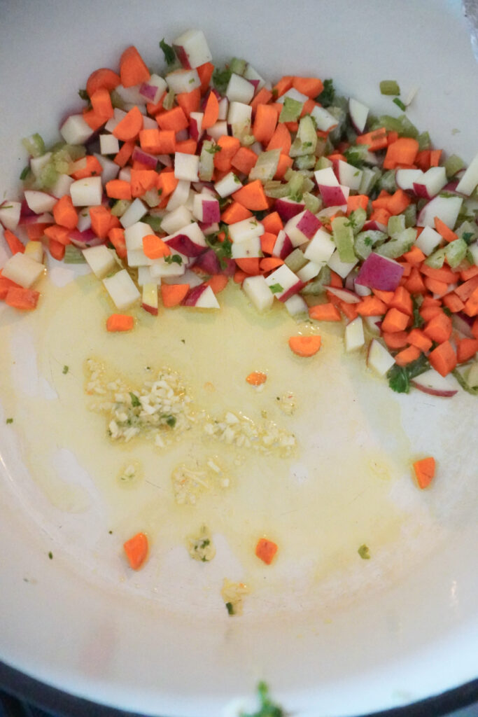 carrots, celery, red potato, and garlic with olive oil in a pot