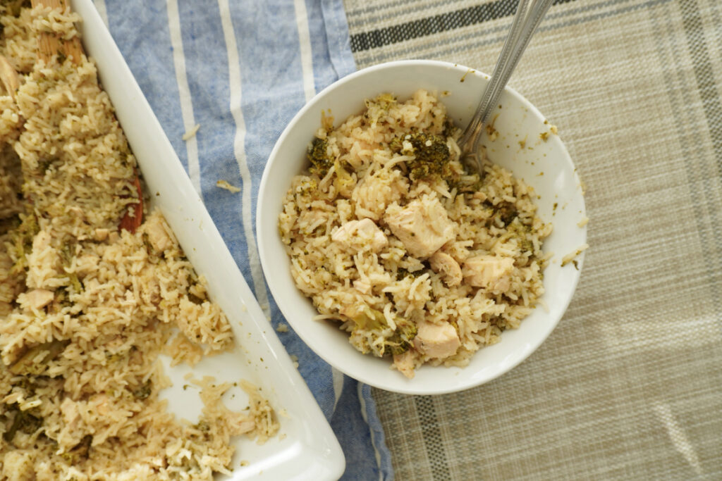 a bowl of broccoli chicken rice casserole next to the serving dish 