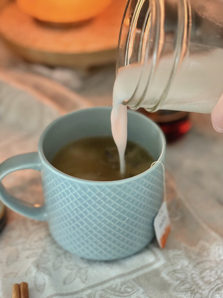 milk being poured from a jar into a mug of hot tea